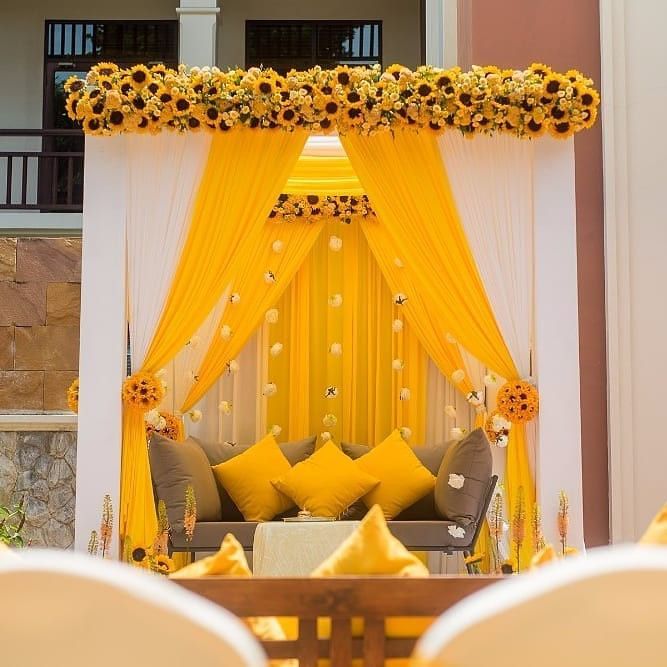 a decorated stage with sunflowers and yellow drapes