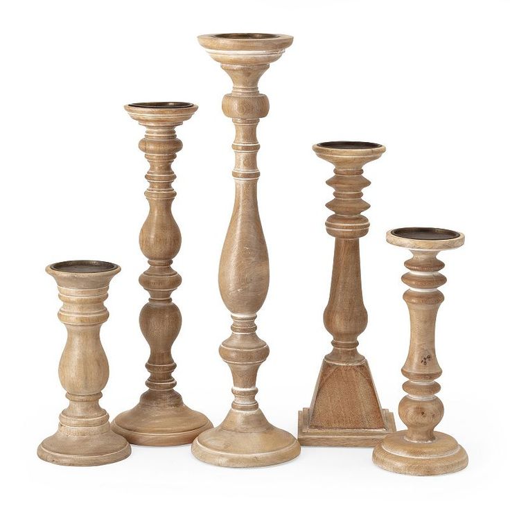 an assortment of wooden candlesticks on a white background