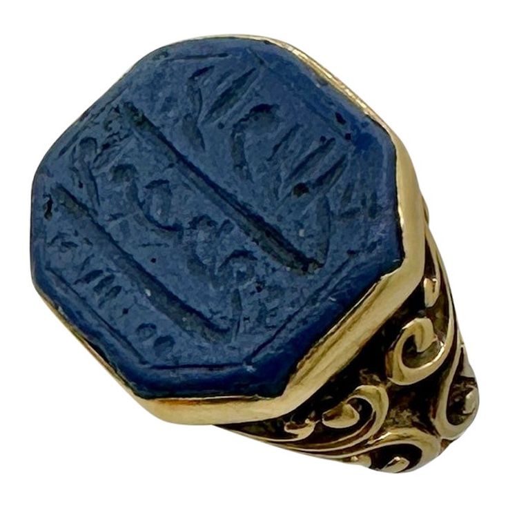 This is a stunning early antique Egyptian Revival Ring with Lapis Lazuli engraved with Arabic or Heiroglyphics in 18 Karat Gold. The fabulous ring has a wonderful blue octagonal lapis center with elegant engraving which I believe is arabic writing. The lapis is set in a cut down collet. The ring shank is a fabulous scroll open work design in 18 Karat Gold. It is very rare to find the early antique Egyptian Revival jewels, and the combination with the engraved lapis with the stunning gold work is extraordinary. For centuries, Ancient Egypt has held the fascination of the public and continues to inspire artists and designers alike. With the discoveries of Egyptian tombs, and the treasures within, in the middle of the 19th century and early 20th centuries, the exotically opulent lives of the Egyptian Revival Jewelry, Arabic Writing, Ring Shank, Egyptian Revival, Work Design, Gold Work, Ancient Egypt, Cocktail Rings, Lapis Lazuli