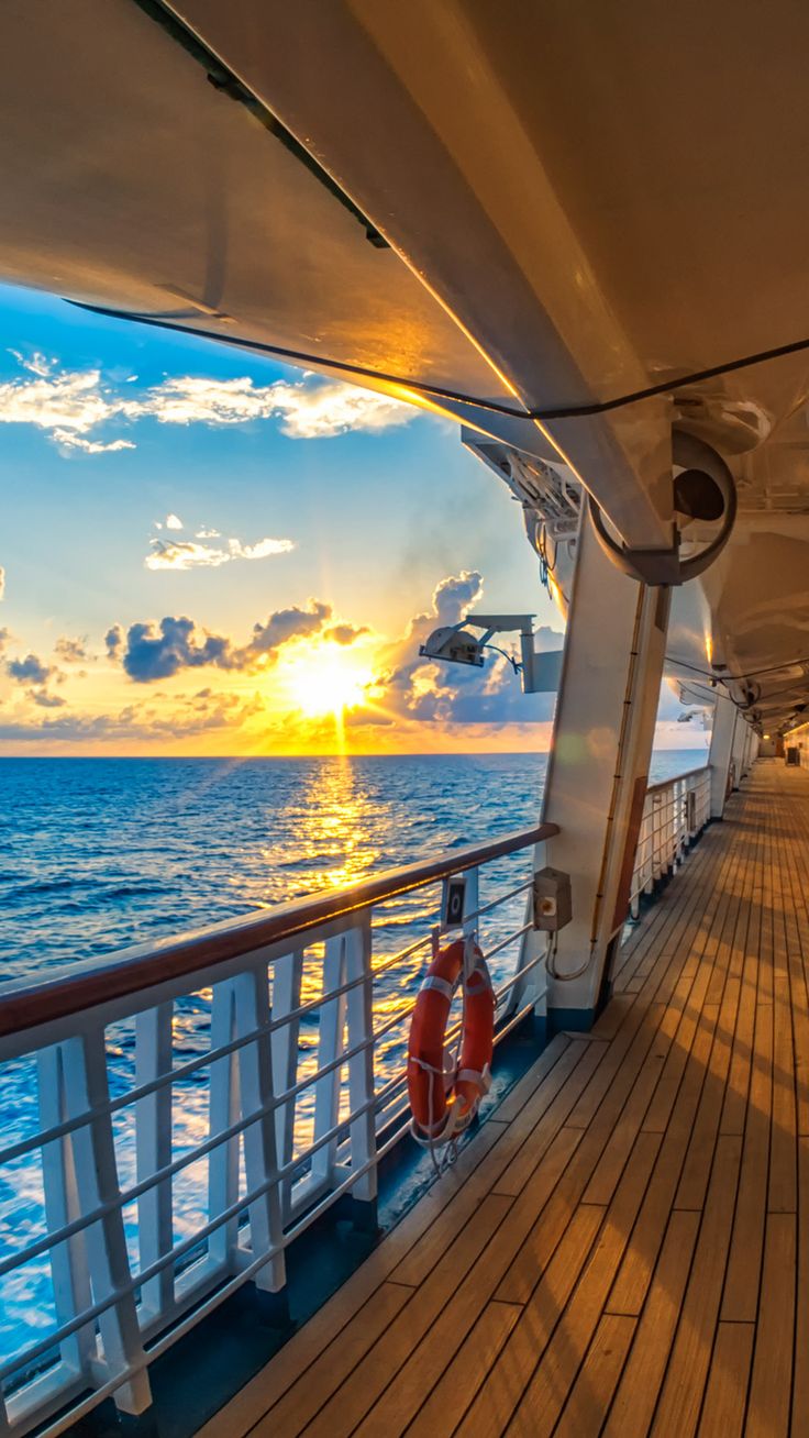 the sun is setting over the ocean as seen from a deck on a cruise ship