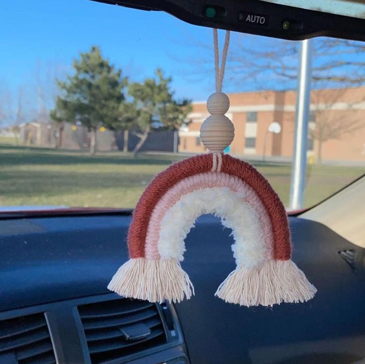 a car dashboard decoration with a rainbow hanging from it