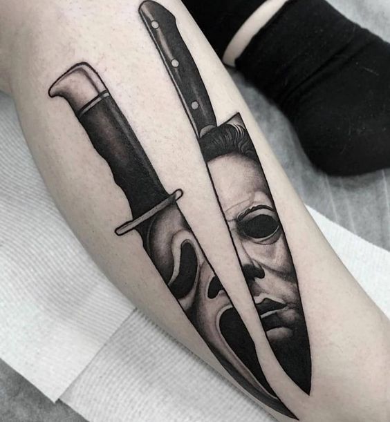 a tattoo with two knives and a mask on it