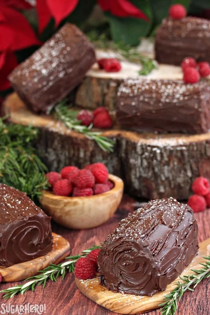 chocolate desserts with raspberries and greenery on wooden boards next to red flowers