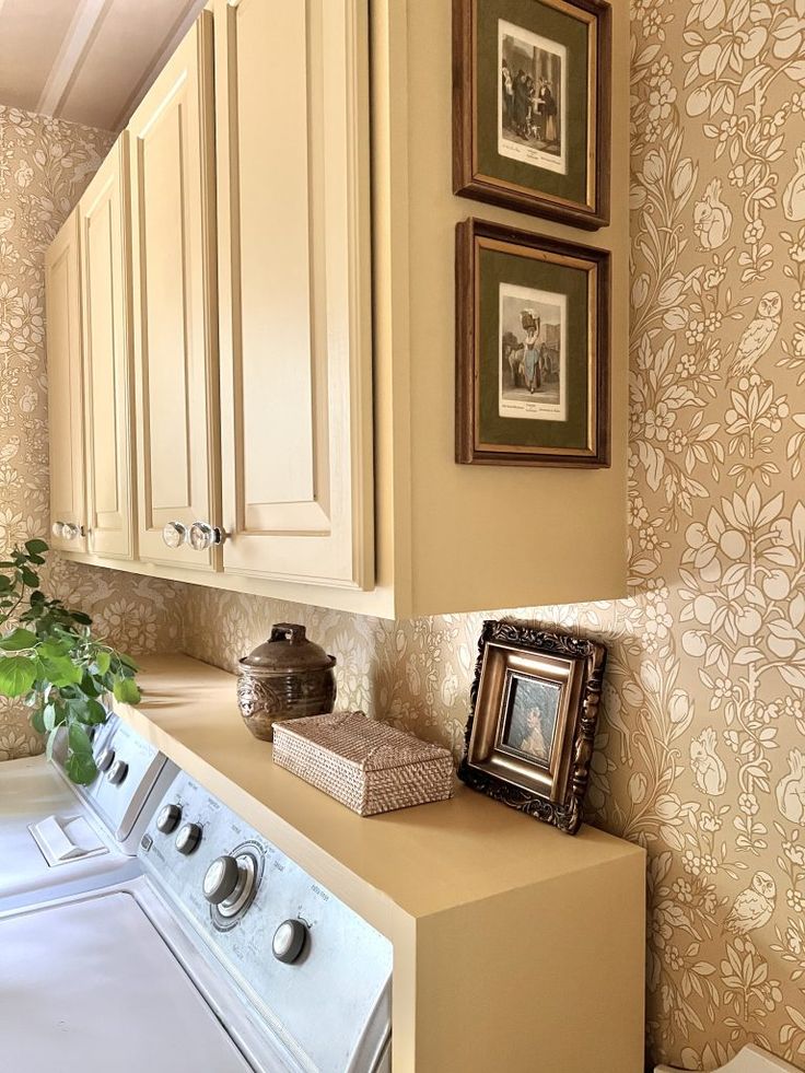 a washer and dryer in a small room with wallpaper on the walls