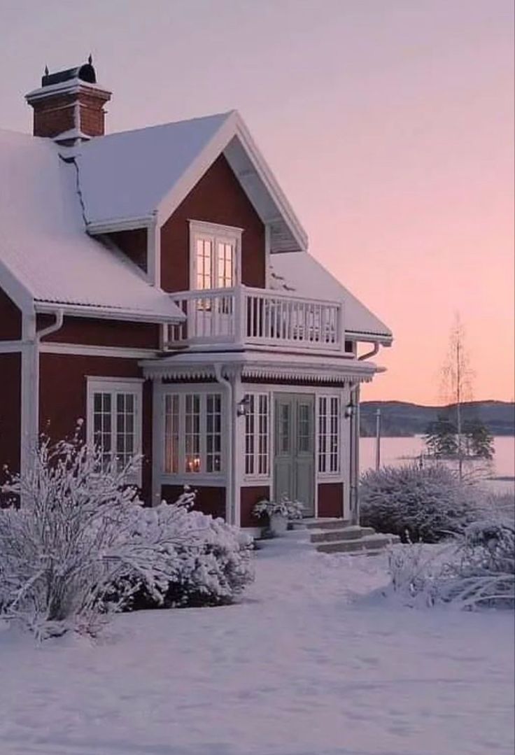 a red house is covered in snow at dusk