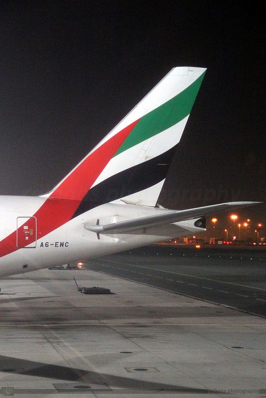 an airplane is parked on the tarmac at night with its lights on and it's tail lit up