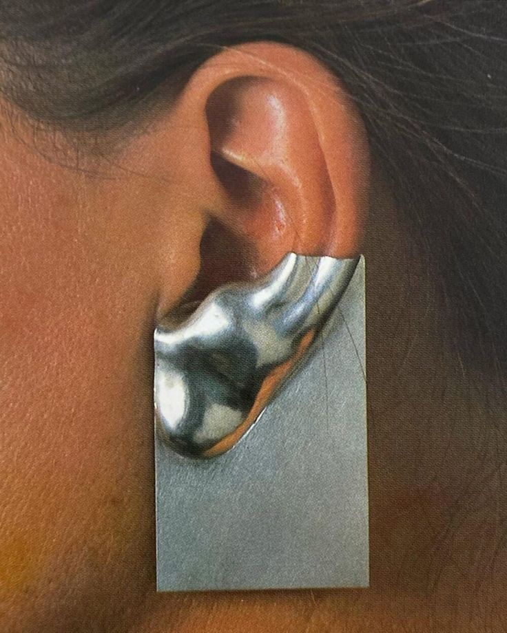 a woman's ear is shown with a square shaped metal object in the middle