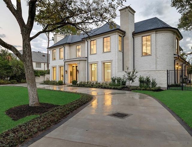 a large white house sitting on top of a lush green field