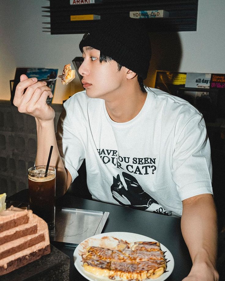 a young man sitting at a table eating food