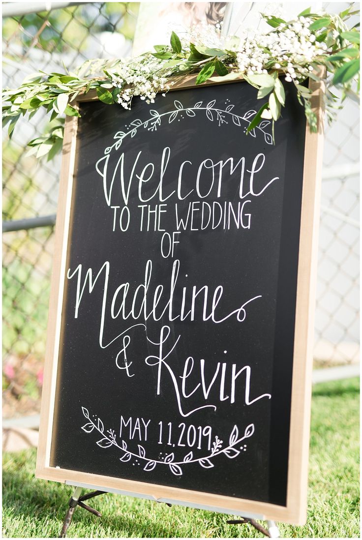 a chalkboard sign that says welcome to the wedding of madeleine and revn on it