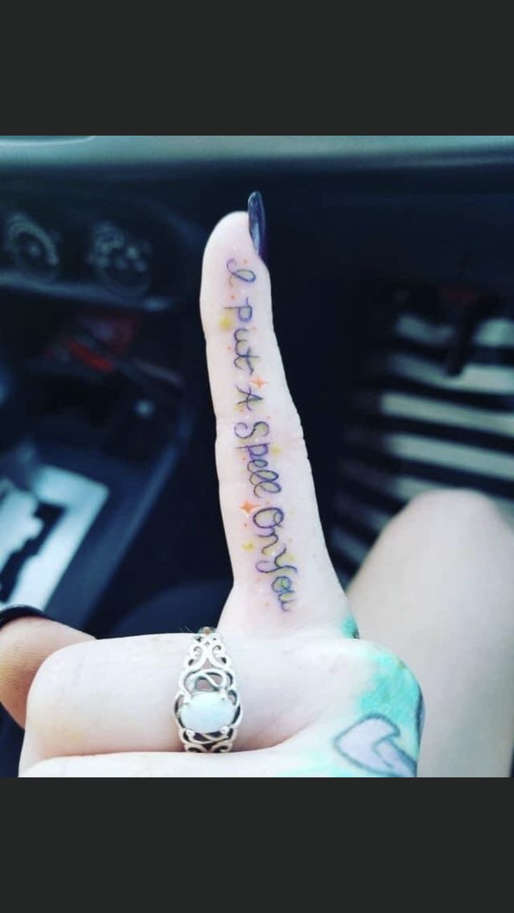 a person is holding up their finger with the word love written on it