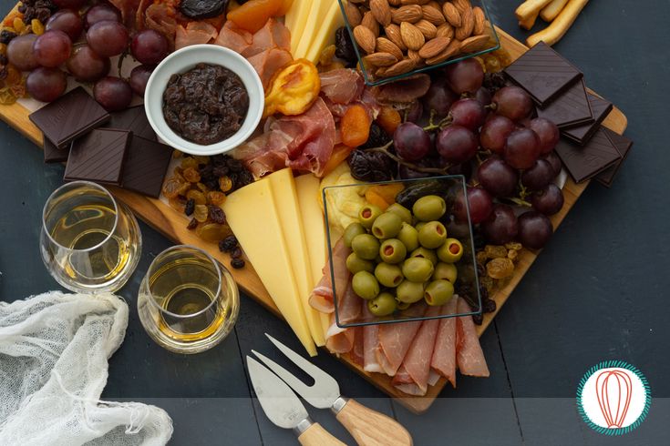 an assortment of cheeses, meats and olives on a platter