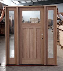 two people are standing in front of a wooden door with glass panels on the side