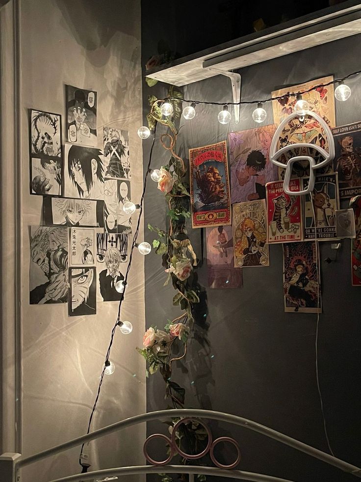 a bunch of posters are hanging on the wall next to a bed with white lights