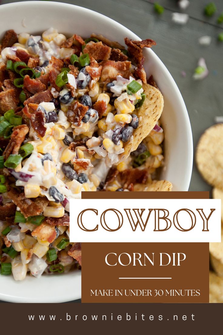 a bowl filled with corn dip next to chips