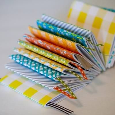 a stack of folded papers sitting on top of a white table next to each other