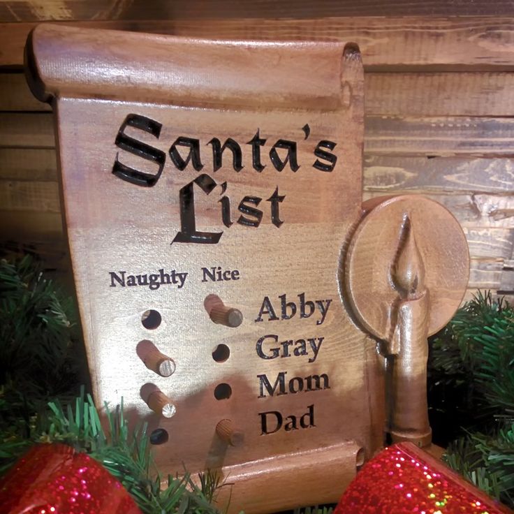 a wooden sign that says santa's list and two red christmas ornaments in front of it