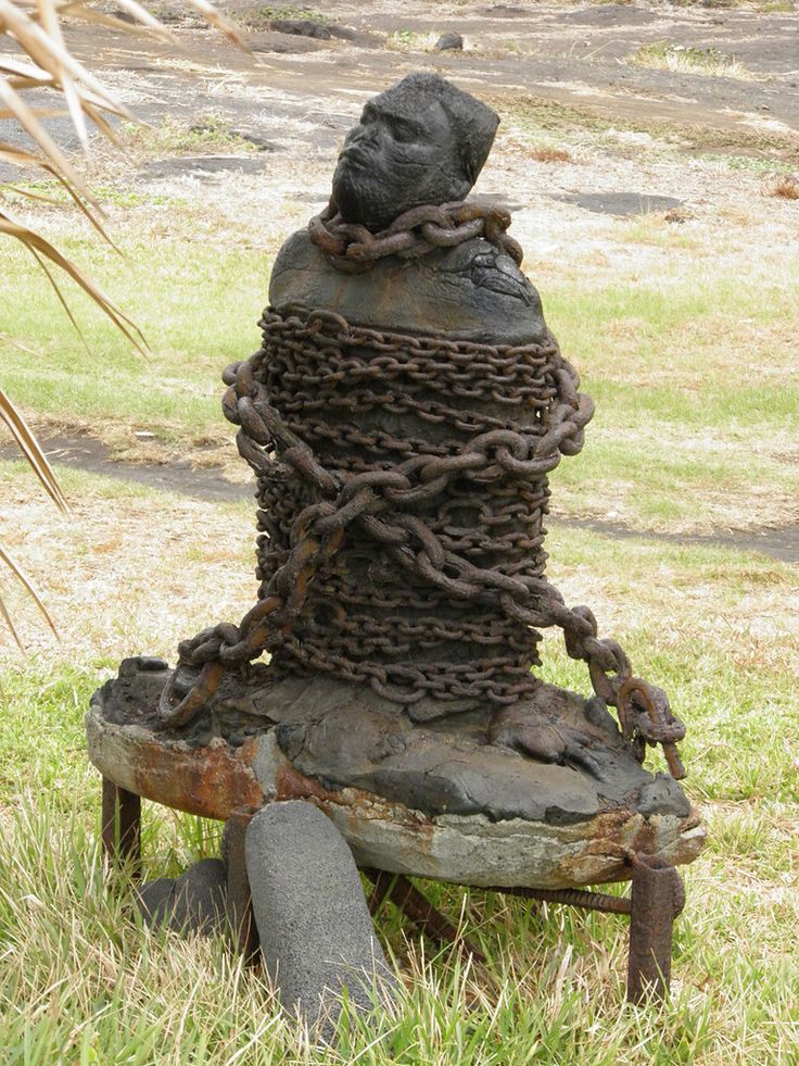 there is a statue made out of chains on top of an old chair in the grass