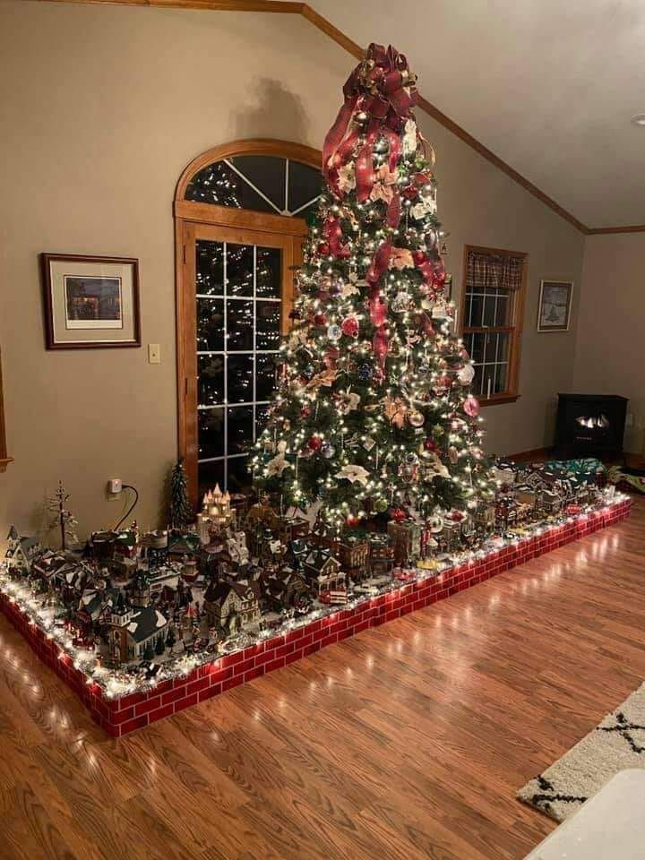 a large christmas tree is in the middle of a room with many toys on it