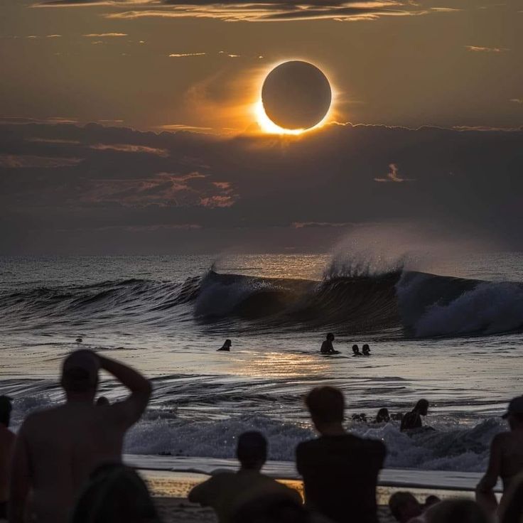 people are watching the eclipse at sunset on the beach with surfers in the water