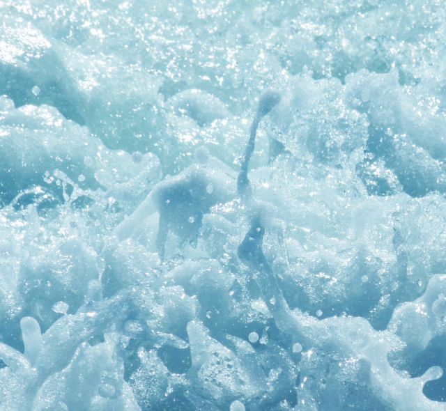 the water is blue and foamy with little bubbles on it's surface as seen from above