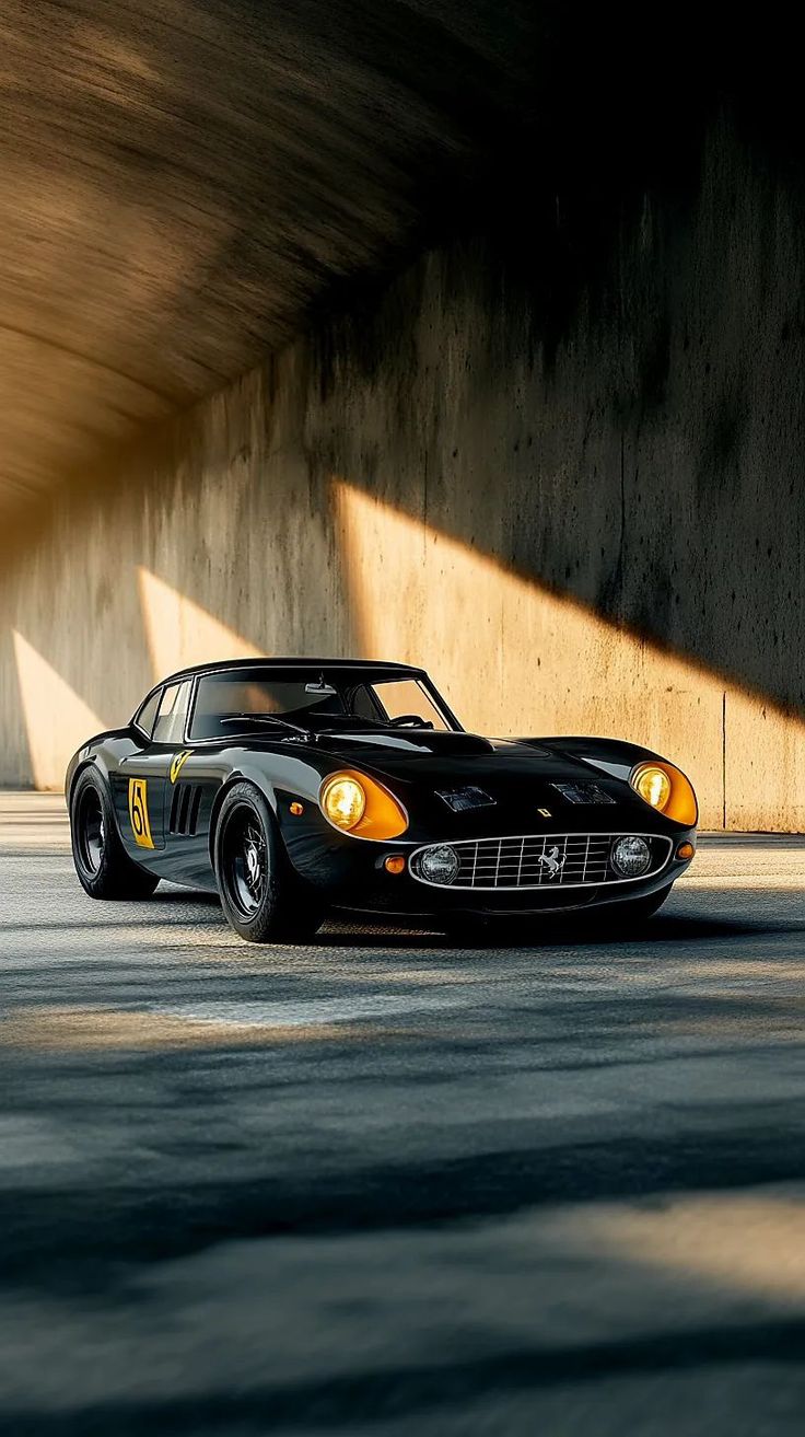 a black sports car is parked in an empty parking lot with the sun shining on it