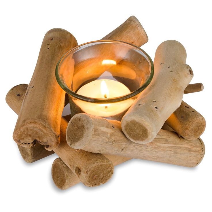 a candle is lit in a glass bowl surrounded by wooden logs