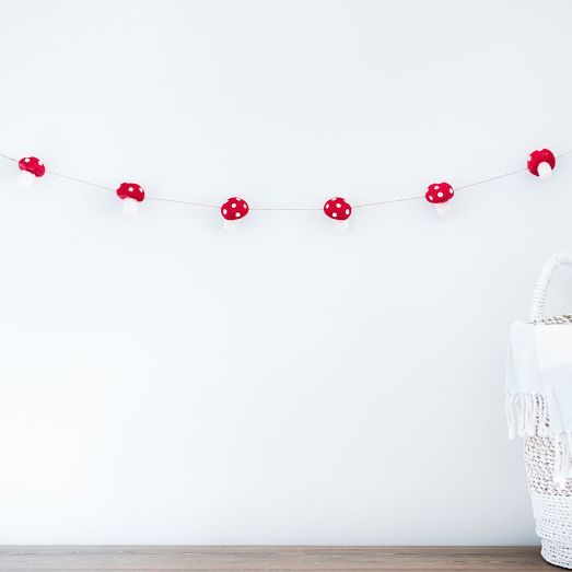 a white basket sitting on top of a wooden table next to a red string light