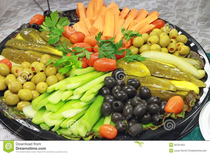 a platter filled with olives, carrots, cucumbers and other vegetables