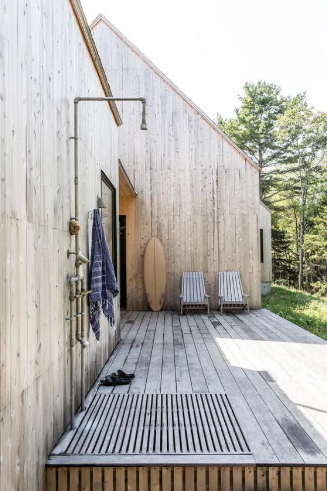 a wooden deck with two chairs and a towel hanging on the wall next to it