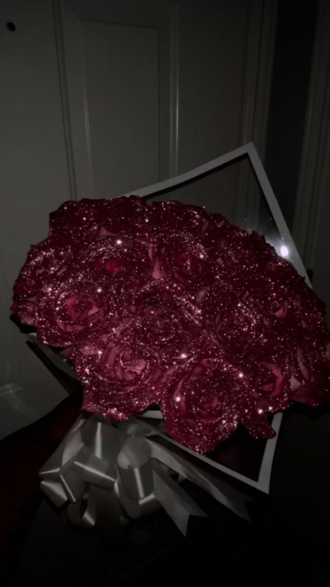 a large red piece of art sitting on top of a metal stand in front of a door