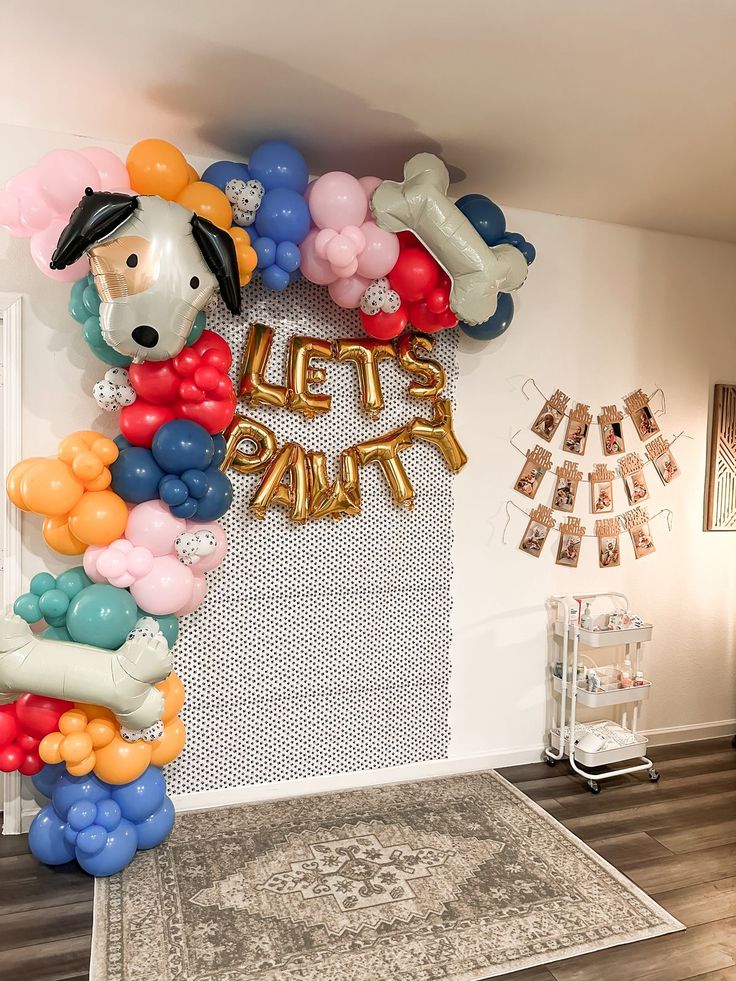 a balloon arch that says let's party with balloons in the shape of dogs