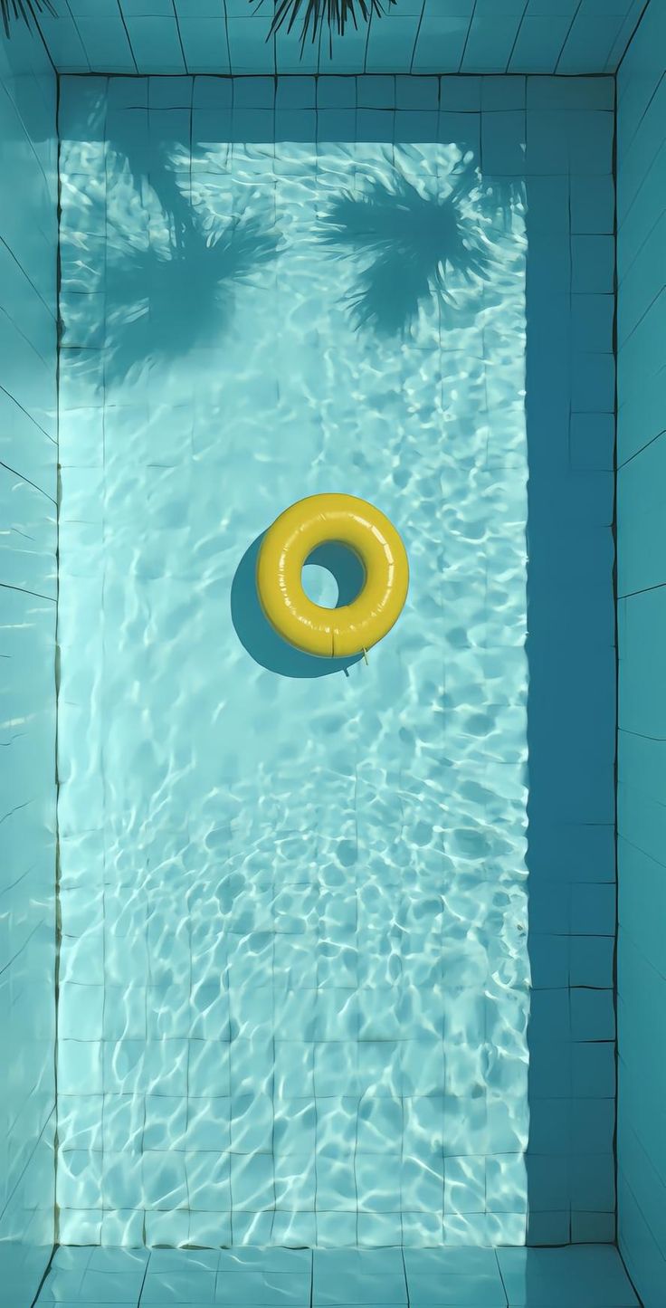 an empty swimming pool with a yellow ring floating in it