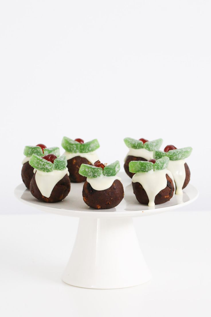 small desserts with white frosting and green candies on a cake plate, ready to be eaten