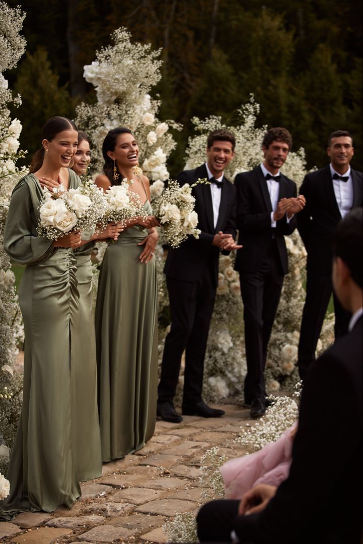 the bride and grooms are walking down the aisle with their bouquets in hand