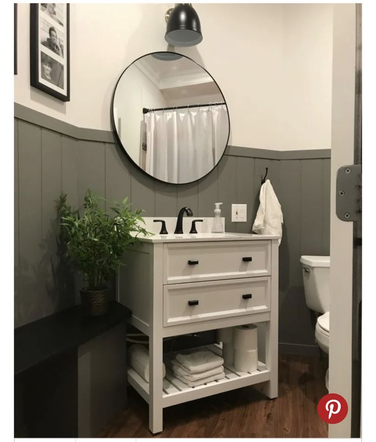 a bathroom with a sink, mirror and potted plant on the counter in front of it