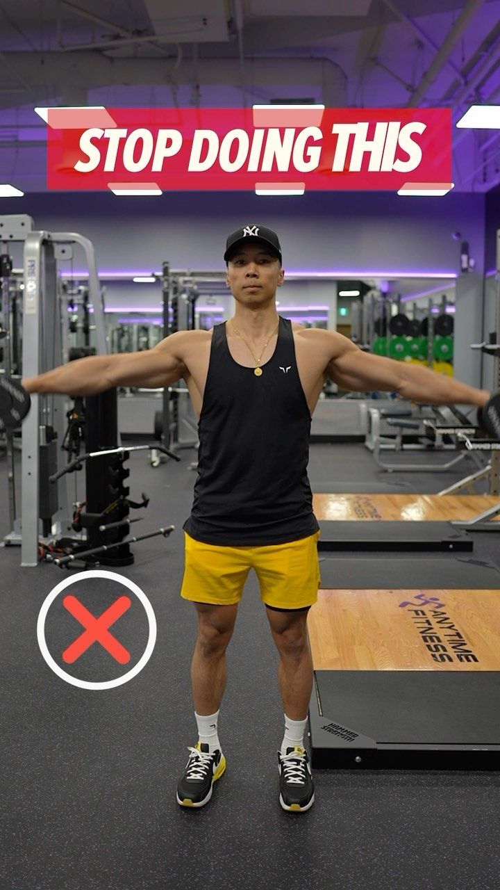 a man standing in the middle of a gym holding his arms out with both hands