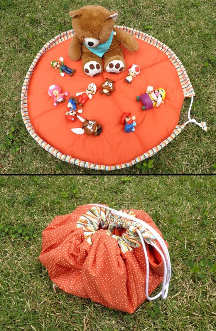 an orange bag filled with toys sitting on top of a grass covered field next to a stuffed animal