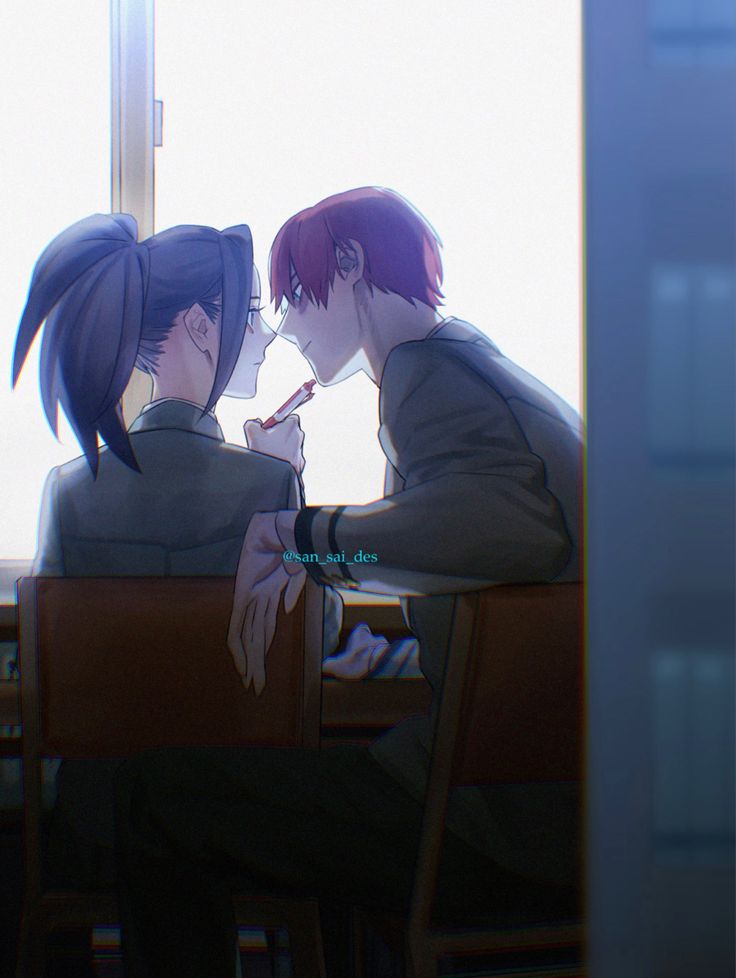 two people sitting at a table in front of a window with their faces close to each other