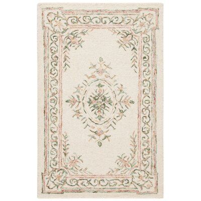 a white rug with an ornate design on the front and back side, in various colors