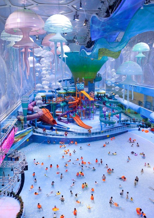 an indoor water park filled with lots of people