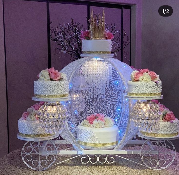 a wedding cake is displayed in front of a window with lights and decorations on it