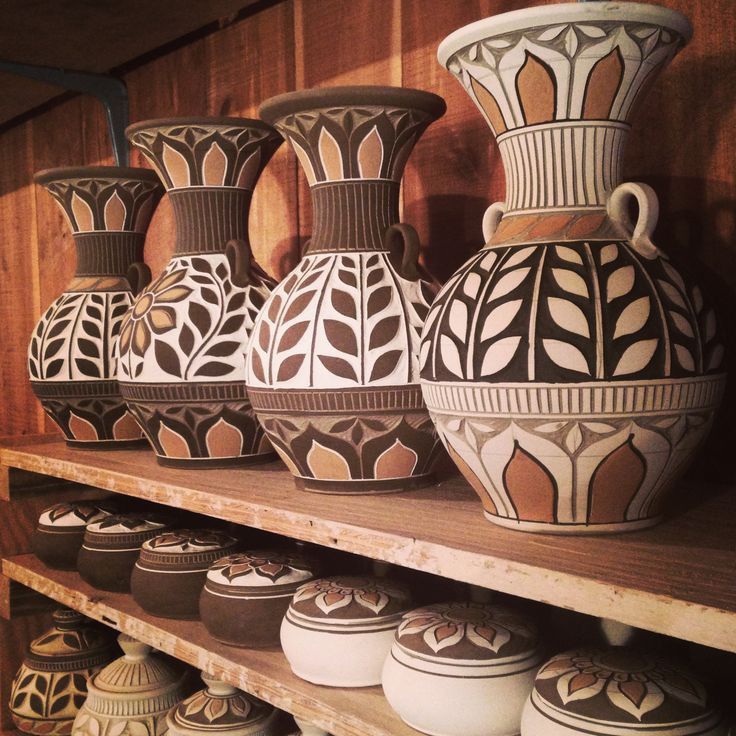 many vases are sitting on shelves in a room