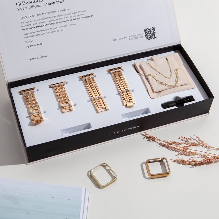 an open box with four different types of bracelets and necklaces in it on a table