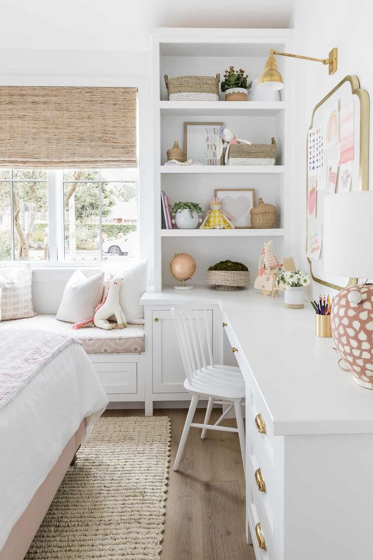 a bedroom with white walls and shelves filled with books, toys, and other items