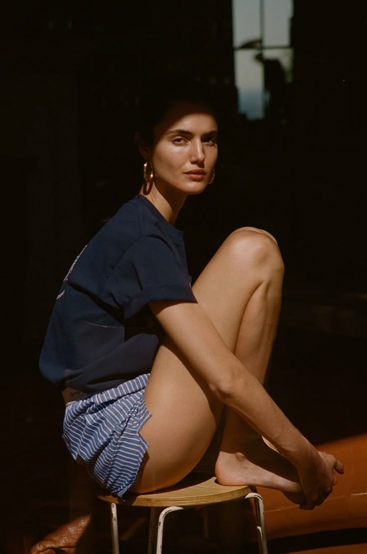 a woman sitting on top of a wooden stool