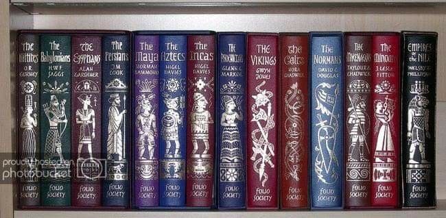 a row of books sitting on top of a wooden shelf