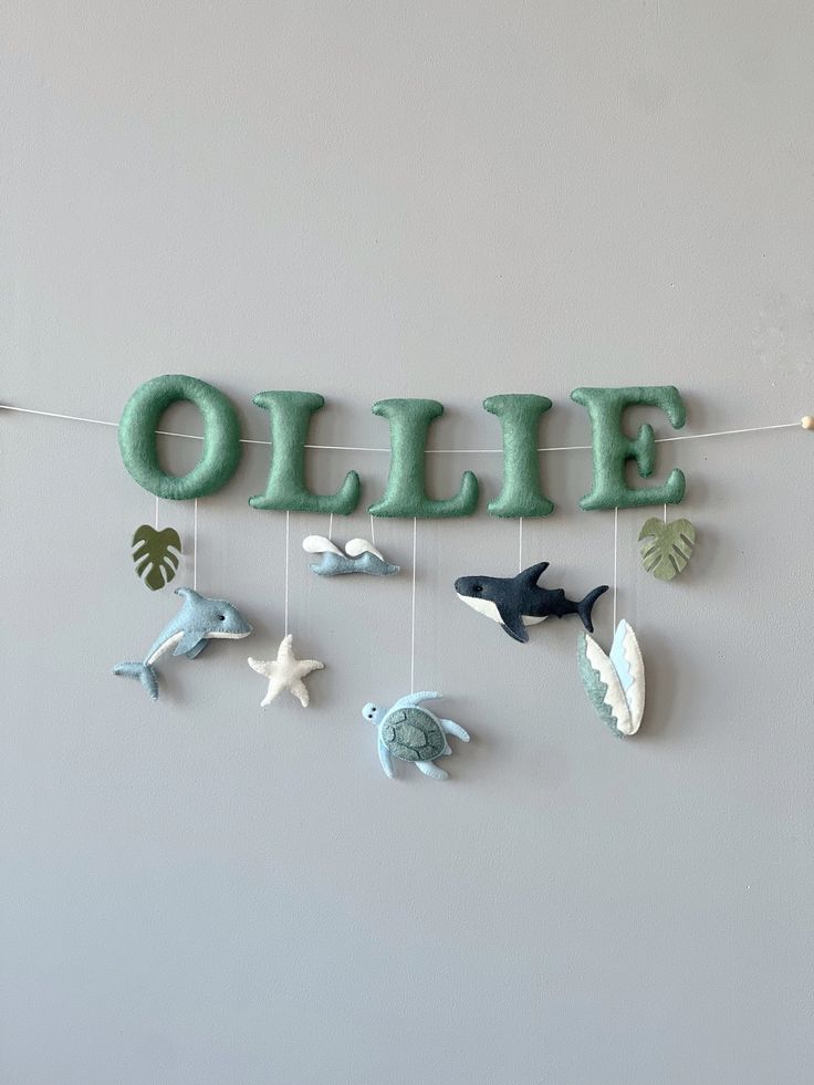 the word ollie is hanging from a string with sea animals