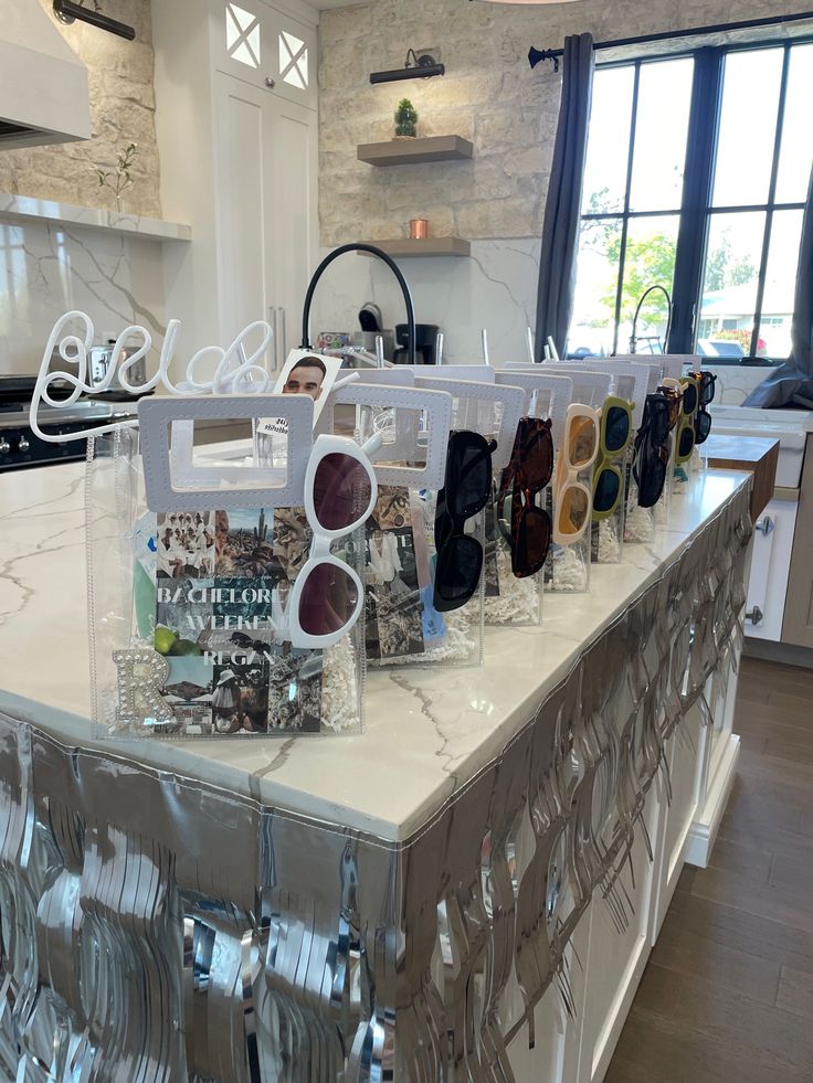 a kitchen counter with glasses on it in front of a window and a sign that says gourmet