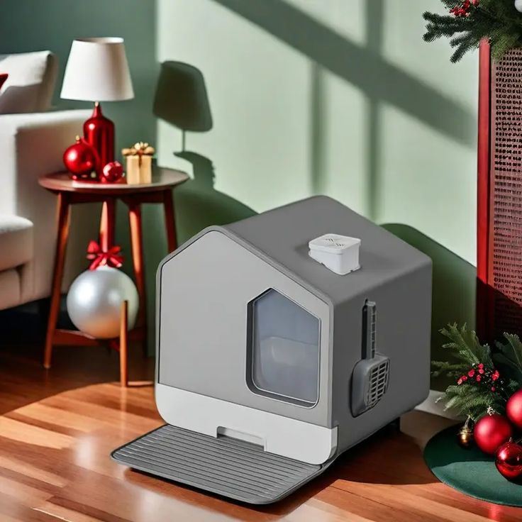 a small gray microwave oven sitting on top of a wooden floor next to christmas decorations